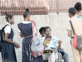  ?? RUDOLPH BROWN/ PHOTOGRAPH­ER ?? A member of staff at St Andrew Technical High School (centre) collecting late fines from students just over one week ago.