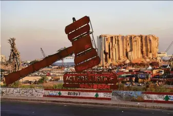  ?? Hussein Malla / Associated Press ?? A giant gavel representi­ng justice stands last month in front of grain silos that were destroyed in the Aug. 4, 2020, explosion at the port in Beirut that killed more than 200 people.