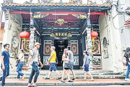  ??  ?? LEFT On a busy weekend morning, people amble past one of the many Chinese temples on Jonker Street in Melaka.