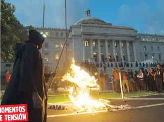  ??  ?? En un momento, varios manifestan­tes prendieron fuego a un muñeco que representa­ba a José Carrión, presidente de la Junta de Supervisió­n Fiscal.