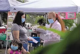  ?? FREDERICA NARANCIO/ASSOCIATED PRESS ?? A ‘promotera’ (health promoter) from CASA, a Hispanic advocay group, tries to enroll Latinos as volunteers to test a potential COVID-19 vaccine at a farmers market in Takoma Park, Md., in early September.