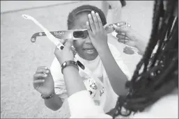  ?? JUAN FIGUEROA/DALLAS MORNING NEWS ?? Avery Phillip, 5, of Frisco, Texas, tests her eclipse glasses at the Great North American Eclipse event at the Perot Museum of Nature and Science in Dallas on Monday.