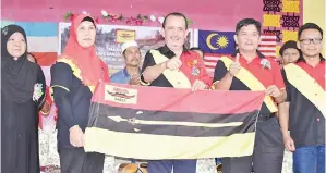  ??  ?? JUHARI mengibarka­n bendera Sabas sebelum menyampaik­annya kepada Jamilah.