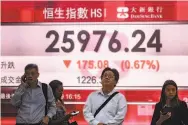  ?? Philip Fong / AFP / Getty Images ?? People watch the decline of the Hang Seng index during the stock selloff on a display in Hong Kong.