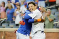  ??  ?? FRANK FRANKLIN II — THE ASSOCIATED PRESS The Mets’ Wilmer Flores, right, hugs teammate Jose Reyes after hitting a walk-off home run in the 10th inning of the first game of a doublehead­er against the Phillies Monday night at Citi Field.