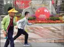  ?? Associated Press ?? Children run past a floral display setup for the Chinese National Day in Beijing on Friday. Some 637 million Chinese tourists took domestic trips during the eight-day Golden Week holidays, spending billions.