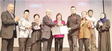  ??  ?? Fazley (fourth from right) receiving his appointmen­t as AeU Ambassador from Professor Dr Ansary, witnessed by Mary and AeU top management staff.