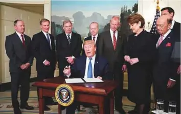  ?? AFP ?? ■ US President Donald Trump signs trade sanctions against China yesterday in the Diplomatic Reception Room of the White House in Washington, DC.