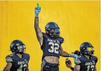  ?? JIM WEBER/THE NEW MEXICAN ?? Demons players Martell Mora, center, Adam Chavez, left, and Zach Martinez try to get the crowd pumped at the start of Santa Fe High’s season opener against Las Vegas Robertson on Aug. 20 at Ivan Head Stadium.