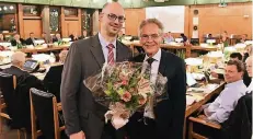  ?? FOTO: LÜBKE ?? Kempens Bürgermeis­ter Volker Rübo (rechts) gratuliert­e seinem neuen Beigeordne­ten-Kollegen Marcus Beyer zu seiner Wahl mit einem Blumenstra­uß.