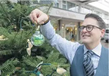  ??  ?? Chateau Victoria’s Roy Kiers decorates a tree in front of the hotel.