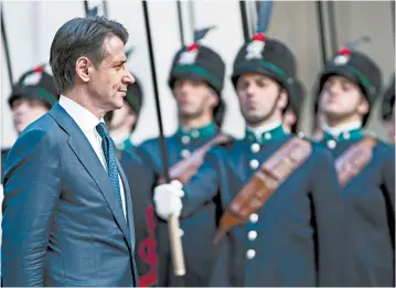  ?? ANGELO CARCONI/ANSA ?? Italian Premier Giuseppe Conte, a law professor and political novice, reviews the honor guard Friday before the start of a meeting in Rome. He taught classes up until Thursday.