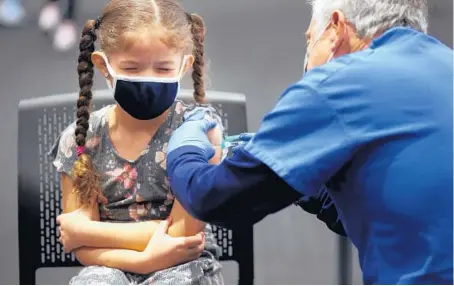  ?? ANTONIO PEREZ/CHICAGO TRIBUNE ?? Lyanise Ramos, 7, receives her COVID-19 vaccine from Dr. Larry Domont on Nov. 12 during a free vaccinatio­n event in Chicago.