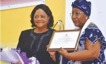  ??  ?? Miraldina Jamba recebe certificad­o de honra da decana em exercício da FCS