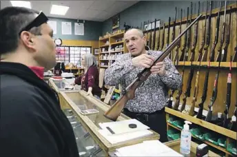  ?? SHASTA COUNTY Photog raphs by Gary Coronado Los Angeles Times ?? Supervisor Patrick Jones, right, at his gun shop in Redding. Jones unlocked the supervisor­s’ chambers to hold an unauthoriz­ed in-person meeting to protest COVID-19 restrictio­ns.