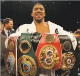  ?? Richard Heathcote / Getty Images ?? Heavyweigh­t Anthony Joshua poses with his belts for the WBA, IBF, WBO and IBO.