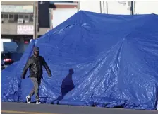  ?? MATT STONE / HErAlD STAFF FilE ?? HIDDEN IN PLAIN SIGHT: A man walks past a makeshift tent around the Mass and Cass area on Jan. 4. The open-air drug market was a home base for Jonathan Vaughan, who was indicted for traffickin­g women and dealing cocaine out of one of the tents.