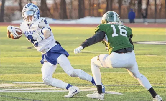  ?? Jenn March / Special to the Times Union ?? Shaker wide receiver Porter Ninstant evades a tackle attempt by Shenendeho­wa defensive back Jake Stack during their season-opening game on Friday night in Clifton Park. Ninstant picked up 16 yards on his one reception in the Blue Bison’s road victory over the Plainsmen.