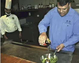  ?? The Yomiuri Shimbun ?? Neeraj Tyagi cooks a dish using soy sauce at his restaurant in New Delhi in December.