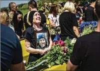  ?? ?? Yaroslava Sushko holds a photo of her son, Serhii V. Sushko, during the June 3 funeral in Dnipro, Ukraine, for 27 Ukrainian servicemen who died fighting the Russians.