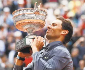  ?? Christophe Ena / Associated Press ?? Rafael Nadal celebrates his record 12th French Open title after beating Dominic Thiem in the men’s final on Sunday.