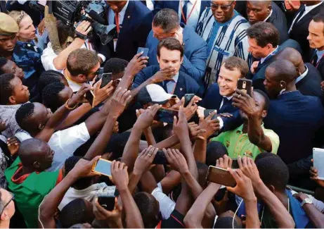  ?? (LUDOVIC MARIN/AFP PHOTO) ?? Emmanuel Macron prenant un bain de foule après son discours à l’Université de Ouagadougo­u, hier mardi.