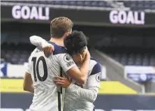  ?? Andy Rain / AFP via Getty Images ?? Son Heungmin hugs Harry Kane ( 10) after scoring his 100th goal for Tottenham, and he and Kane tied the English Premier League record for most goal combinatio­ns in a season.