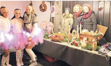  ?? RP-FOTO: UWE HELDENS ?? Die Mitglieder der Tanzgruppe Twister (l.) gestaltete­n den Adventsmar­kt in Holzweiler ebenso mit wie die Aktiven der Interessen­gemeinscha­ft Hellenstra­ße (r.) mit einem Stand.