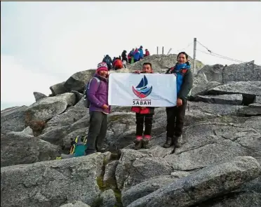  ??  ?? No politics at work: The mountain guides holding the Parti Warisan Sabah flag near the summit of Mt Kinabalu.