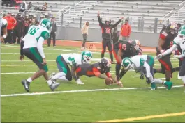  ?? STAFF PHOTO BY AJ MASON ?? North Point junior quarterbac­k Jemichael Jones lunges for a 6-yard rushing touchdown run under the duress of St. Charles defenders late in the second quarter. It was one of his three rushing scores in Friday’s 31-0 win over the Spartans in a SMAC Potomac Division contest.