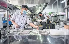  ?? ?? Staff prepare takeaway orders inside a cloud kitchen for Thai restaurant­s under the iBerry Group in Bangkok.