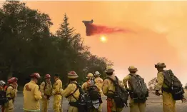  ?? — AP ?? A Cal Fire air taker makes a fire retardant drop on a wildfire as the pilot protects structures on the Hawkeye Ranch above Geyservill­e, California on Thursday.