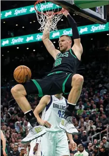  ?? STAFF PHOTO — STUART CAHILL/BOSTON HERALD ?? Boston Celtics center Kristaps Porzingis dunks during the Celtics’ victory over the Dallas Mavericks on Friday night.