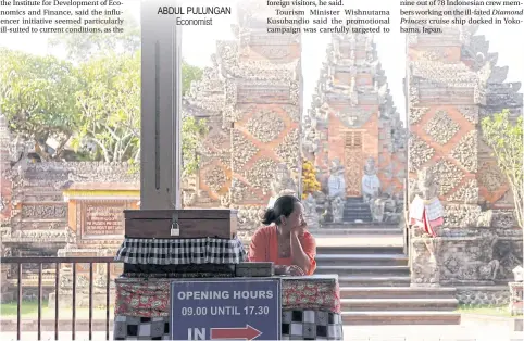  ??  ?? A woman waits for tourists at the Puseh Temple in Gianyar on Bali, where tourism has slowed markedly in the past month.