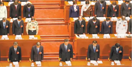  ?? Reuters-Yonhap ?? Chinese President Xi Jinping and other officials observe a moment of silence for victims of COVID-19 at the opening session of the National People’s Congress at the Great Hall of the People in Beijing, Friday.