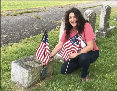  ?? PHOTO COURTESY OF CATHY SKITKO ?? For Memorial Day, Bronwyn DeMaso, a board member of Edgewood Cemetery, places a flag at the headstone of her brother Job, a Navy SEAL.