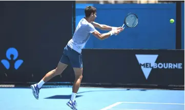  ?? — AFP photo ?? Djokovic hits a return during a practice session ahead of the Australian Open tennis tournament in Melbourne.