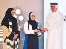  ?? Atiq ur Rehman/Gulf News ?? Eynas Orabi, whose shirt film titled ‘Visual Effects’ won first prize in the ‘Combating Discrimina­tion and Equality’ category, accepts her award from Abdul Karim Julfar in the presence of Maitha Al Shamsi in Dubai on Wednesday.