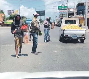  ??  ?? Forzados. Cuando los conductore­s reducen la marcha por los “policías acostados” frente a la Fortaleza “Máximo Gómez”, ahí caen bajo el asedio de vendedores que ofertan de todo.