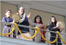  ?? — PTI ?? Lok Sabha Speaker Om Birla with his family members clap and clang utensils as a gesture to show gratitude to medical practition­ers during Janata curfew in New Delhi on Sunday.