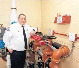  ?? NORTHERN ILLINOIS FIRE SPRINKLER ADVISORY ?? Bedford Park fire Marshall Mark Murray shows the water handling system for sprinklers installed and the department’s headquarte­rs.