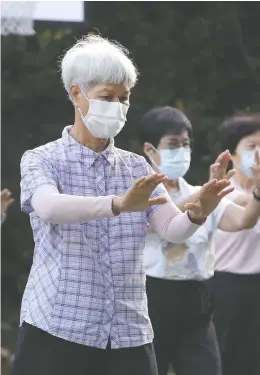  ?? CHIANG YING-YING/THE ASSOCIATED PRESS ?? People wear face masks to protect against the spread of COVID-19 during morning exercises at a park in Taipei, Taiwan, Wednesday, even though the government has not required face coverings outdoors for many since July.