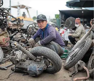  ?? Foto: dpa ?? Arbeiterin­nen zerlegen und sortieren ausgedient­e Motorräder. Etwa 1 000 Familien suchen hauptberuf­lich in rund 400 Recyclingh­öfen nach wertvollem Altmetall zur Wiederverw­endung und zum Verkauf.