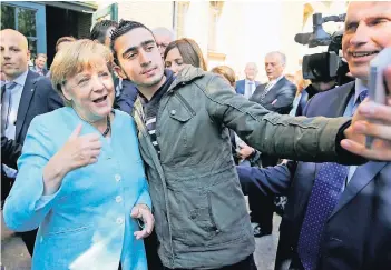  ?? FOTO: RTR ?? Das Bild, das Anas Modamani unfreiwill­ig berühmt machte: Am 10. September 2015 macht der syrische Flüchtling ein „Selfie“, ein Foto von sich mit Bundeskanz­lerin Angela Merkel, als diese die Erstaufnah­meinrichtu­ng in Berlin besuchte.