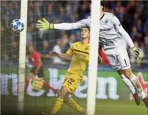  ?? — AP ?? Perfect present: Borussia Dortmund’s Christian Pulisic (in yellow) scoring his side’s first goal as Brugge goalkeeper Karlo Letica dives to stop the ball during a Champions League Group A match in Bruges, Belgium, on Tuesday.