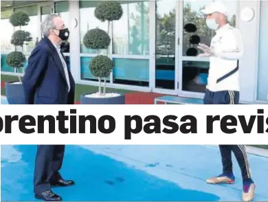  ?? REAL MADRID.COM ?? Florentino Pérez atiende a Zinedine Zidane en la ciudad deportiva de Valdebebas con la distancia de seguridad.