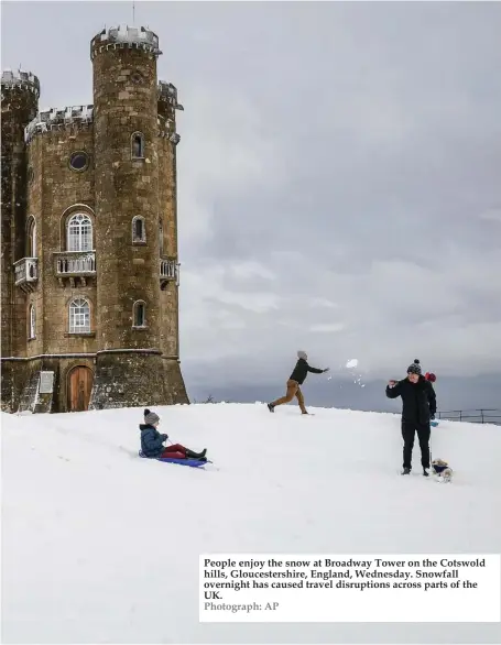  ??  ?? People enjoy the snow at Broadway Tower on the Cotswold hills, Gloucester­shire, England, Wednesday. Snowfall overnight has caused travel disruption­s across parts of the UK. Photograph: AP