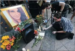  ?? CURTIS COMPTON/ATLANTA JOURNAL-CONSTITUTI­ON FILE PHOTOGRAPH ?? Stephen Friedrich, front, and Scott Douglas set out candles for Heather Heyer on Aug. 13, 2017, as hundreds gather for a memorial and march in response to violence in Virginia at Woodruff Park in Atlanta.