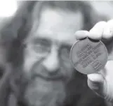  ??  ?? Edwin Eagan holds a U.S. Olympic Hall of Fame medal owned by his great-uncle, Edward Eagan. Lewis Geyer, Times-Call