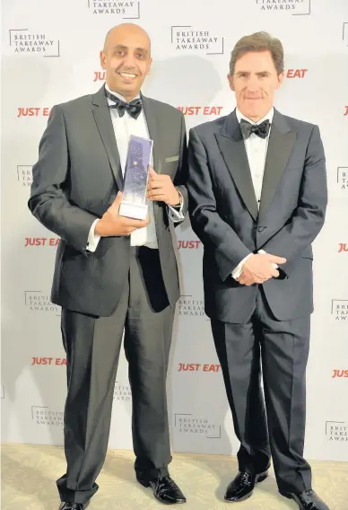  ??  ?? Trophy Ajmal Mushtaq picked up the Best Takeaway in Scotland Award from comedian Rob Brydon, who hosted the ceremony